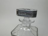 a small glass bottle with a silver lid on a table