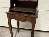 a small wooden desk with a drawer on top of it