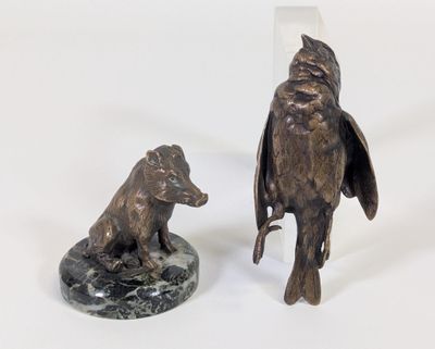 une statue représentant un oiseau et un ours, posée sur un socle en marbre
