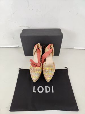 a pair of pink and gold shoes sitting on top of a black bag