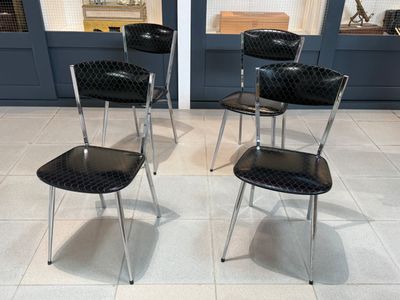 quatre chaises qui sont assises ensemble dans une pièce