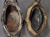 pair of antique silver plated objects on a gray background