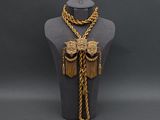 a mannequin with a gold chain and a necklace on it