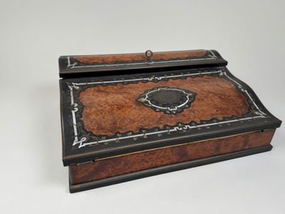an old wooden box with a black and brown design on it