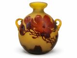 un vase jaune orné de fleurs rouges, posé sur un fond blanc