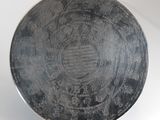 a black plate with writing on it sitting on a stand