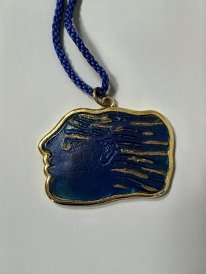 a blue and gold necklace with a woman ' s face on it