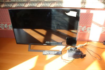 a flat screen tv sitting on top of a wooden table