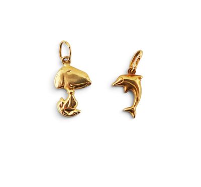 a pair of gold dolphin charms on a white background