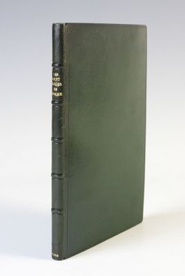 un vieux livre à la couverture noire, orné de lettres dorées