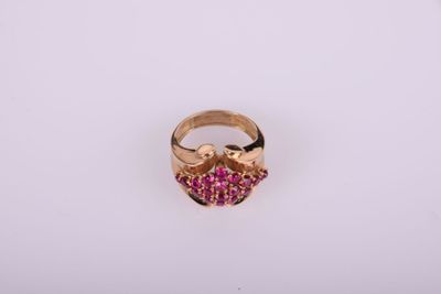 un gros plan d'une bague en or sertie de pierres roses
