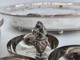 a silver plate with a bird on top of it