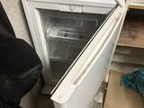 a small refrigerator that has a bottle of water in it