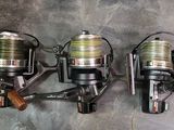 three fishing reels are lined up on a wall next to each other