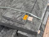 Plusieurs blocs de granit sont empilés sur une palette dans un entrepôt