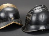 pair of antique fire helmets on black background with gold accents