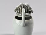 a white vase with a handle and a handle on it