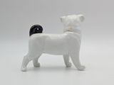 a white and black dog figurine on a white surface