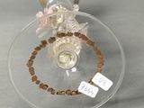 a glass ornament with beads and a tag on it