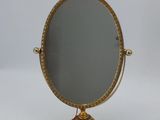 a gold mirror on a stand with a tag on it