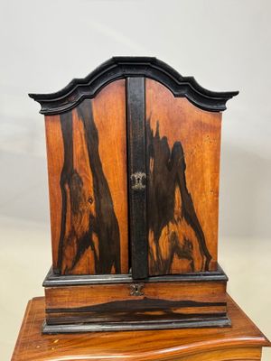 une image représentant une horloge en bois sur laquelle sont peints deux chevaux