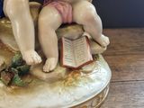 a figurine of a boy and a girl sitting on a bench