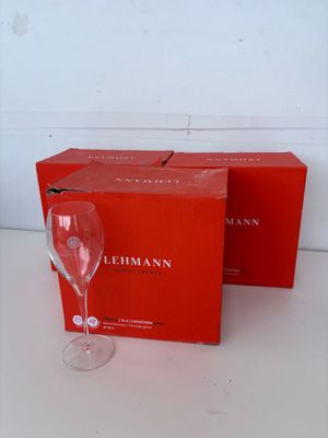 deux verres à vin vides posés sur une table, à côté d'une boîte rouge