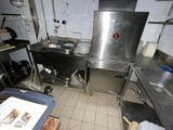 a large stainless steel kitchen with a sink and a stove
