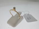 une bague en or ornée d'un diamant et d'une étiquette de prix