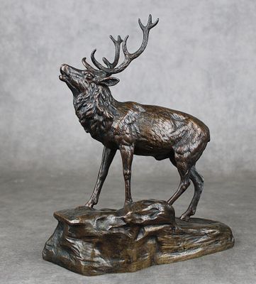 statue d'un cerf debout sur un rocher, avec des bois dans ses bois