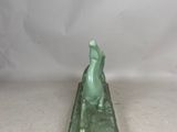 a green statue of a cat sitting on top of a green base
