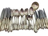 a lot of silver spoons and spoons on the table