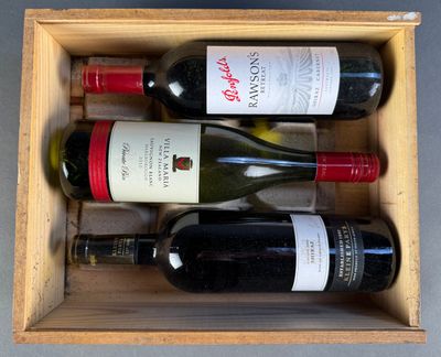 three bottles of wine in a wooden box on a table