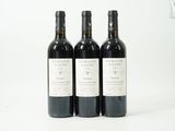 trois bouteilles de vin posées sur une table blanche