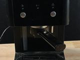 a black coffee machine sitting on a wooden table