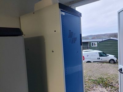 un casier bleu à côté d'un réfrigérateur blanc dans un garage