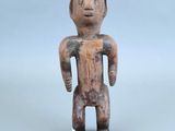 une petite figurine en bois représentant un homme torse nu