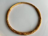 an image of a gold bracelet on a white surface
