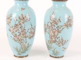 two vases with flowers painted on them on a white surface