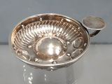 un bol en argent posé sur une table, avec une cuillère à l'intérieur