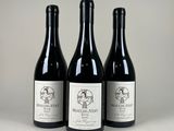 trois bouteilles de vin sont alignées sur une table
