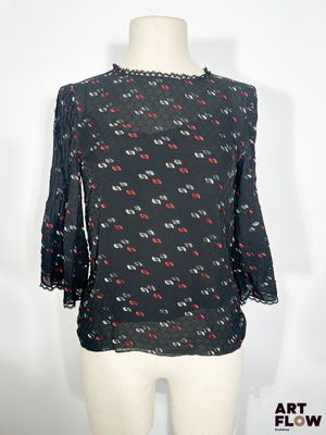 un haut noir orné de cœurs rouges et blancs, présenté sur un mannequin