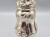 an antique silverplated salt shaker on a pedestal