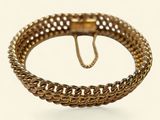 une image d'un bracelet en or sur fond blanc