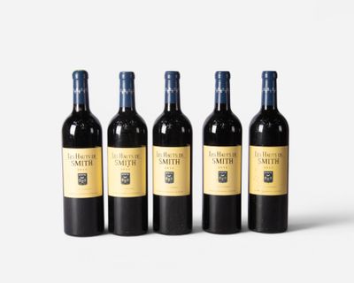 four bottles of wine are lined up on a white surface