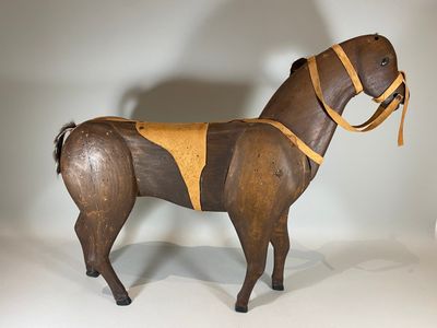 Cheval en bois, lanières et scelle en cuir. Haut : 52 cm - L…