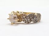 a close up of a gold ring with a white diamond