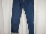 a pair of blue jeans hanging on a hanger on a white curtain