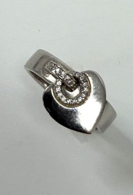 une bague en argent sur laquelle sont gravés un cœur et la lettre « s »