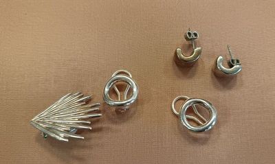 three pairs of earrings and a ring on a table